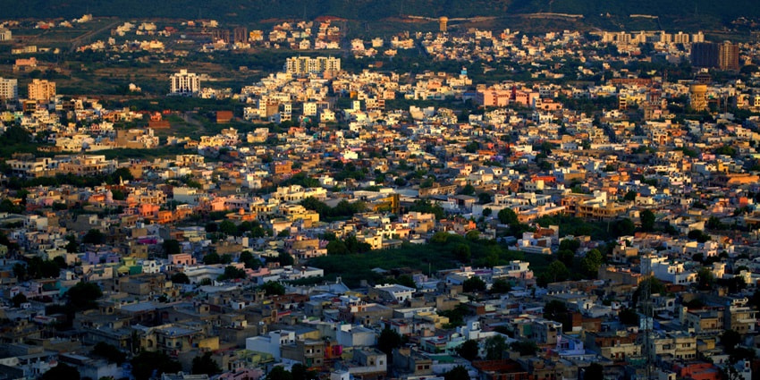 An aerial view of the city of Ajmer during sunrise with the entire cityscape covered in sunlight