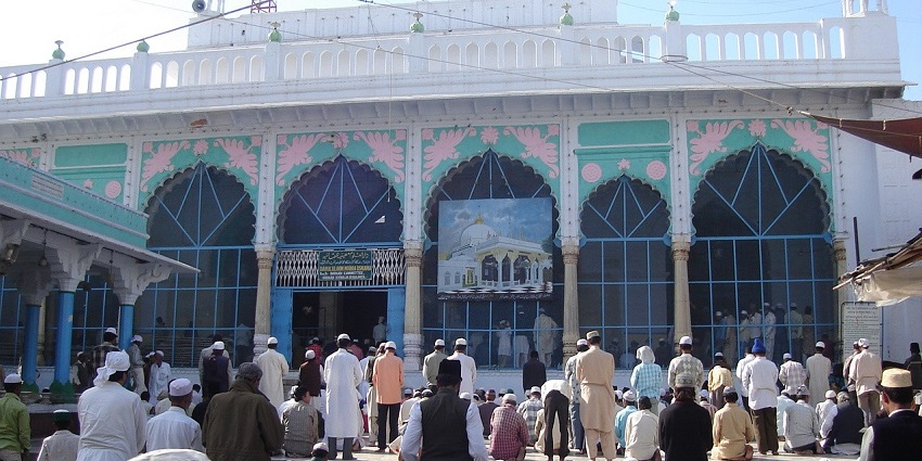 The decorated dome of the Ajmer Sharif Dargah, with people coming to offer prayers.