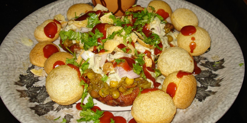 Aloo tikki served with tamarind sauce and curd at the top with a sprinkle of chaat masala
