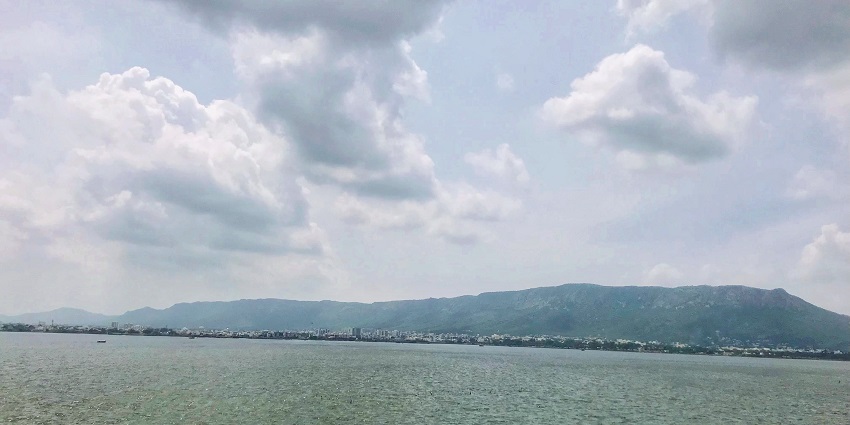 A wide angle view of the picturesque Ana Sagar Lake reflecting the clouds