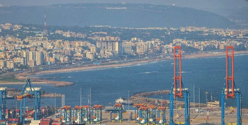 An aerial picture of a large water body with a city in the background with a sea port in front