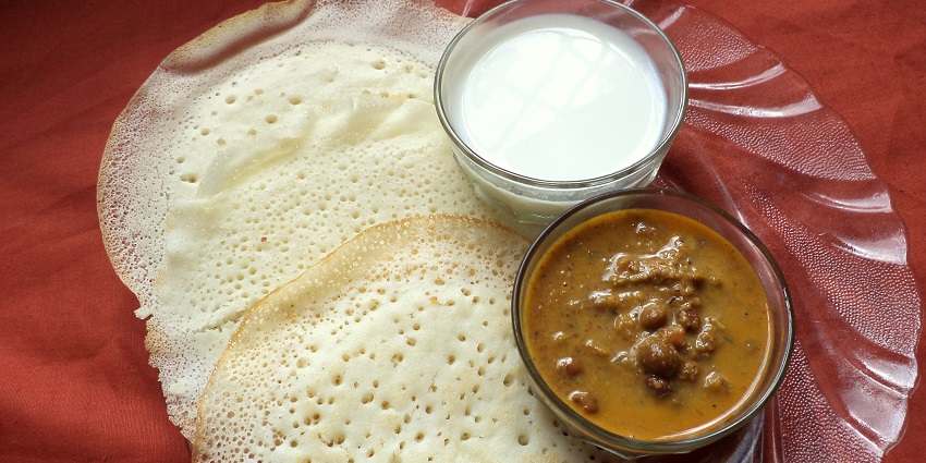 A plate of appams served with Kadala curry, showcasing traditional South Indian cuisine.