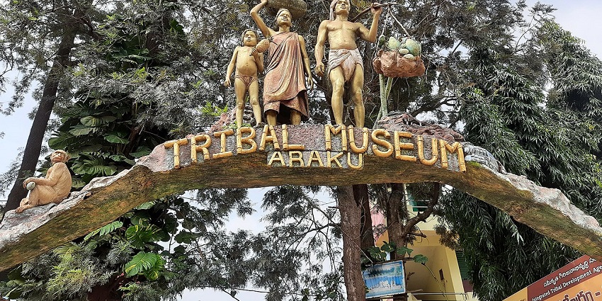 A picture of the entrance of a tribal museum with sculptures of tribal people at the gate