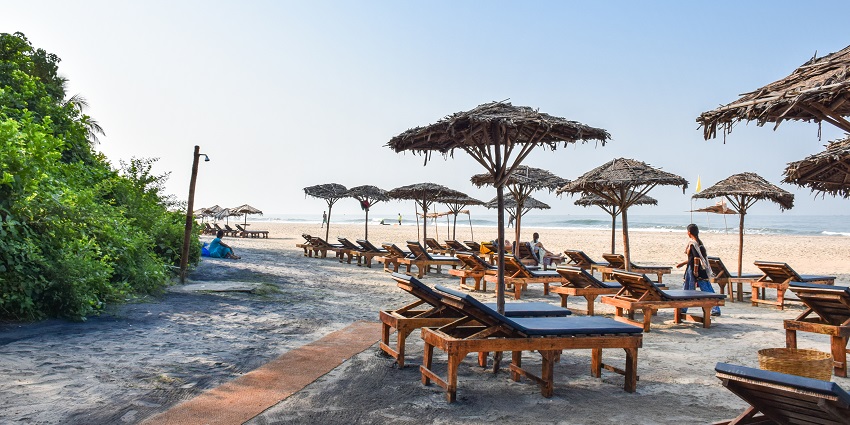 Picturesque view of the beach, lined with cute sheds and lounge chairs