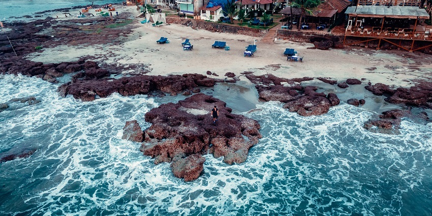 Enchanting view of the waves crashing the golden shores of the Ashwem beach