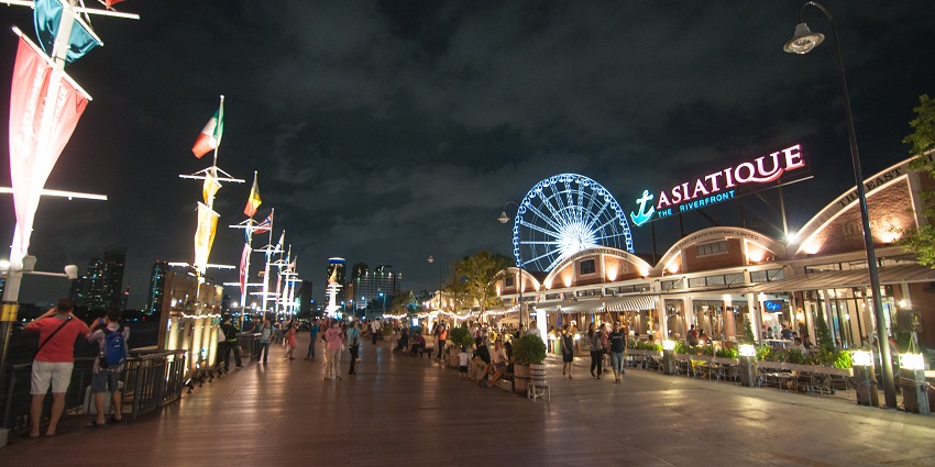 Main entry to the Asiatique mall filled with lights and a giant wheel in the background
