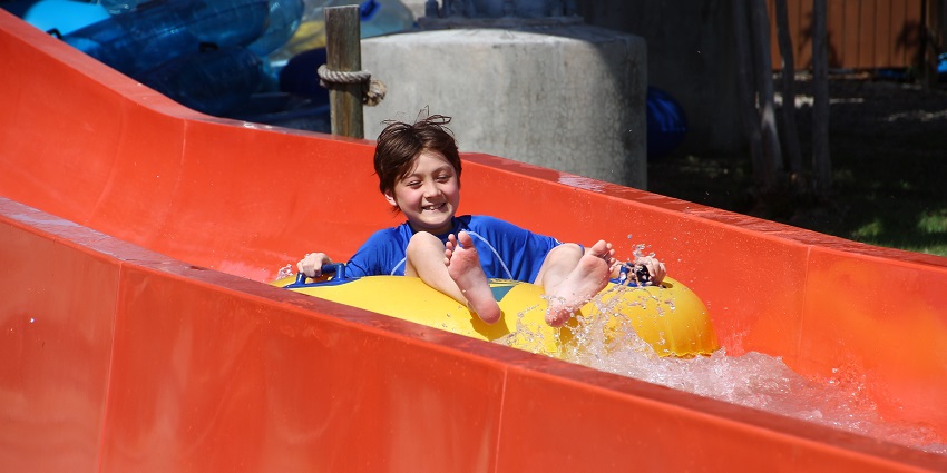 A picture of a child enjoying a water slide at a theme park in Delhi during daytime