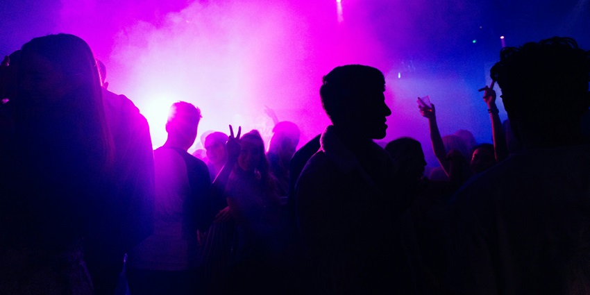 A view of people enjoying and dancing in tune to the vibrant neon lights in Atlas Bar.
