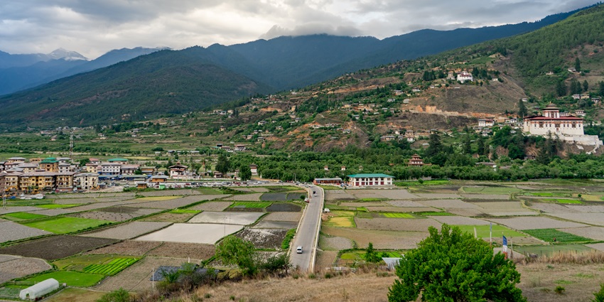 Mountain valley view over Paro Bhutan under soft cloud cover and green fields
