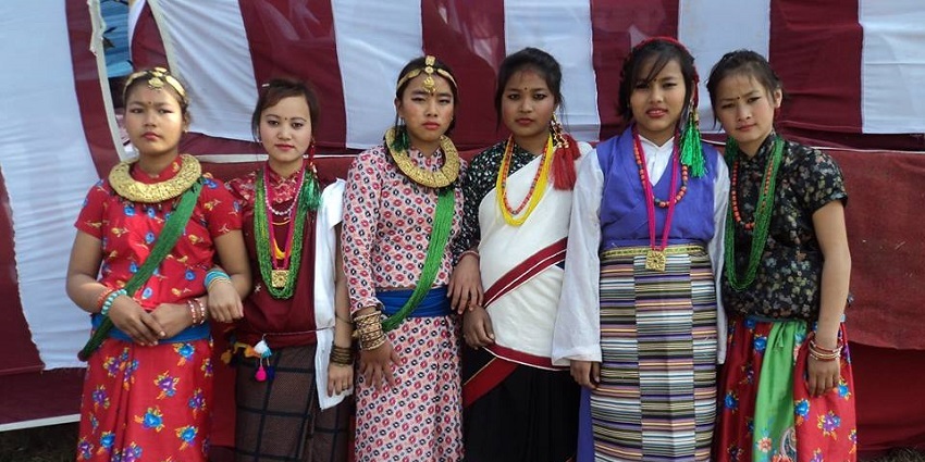 Nepali women in traditional attire, adorned with colourful fabrics and intricate jewellery, smiling warmly.