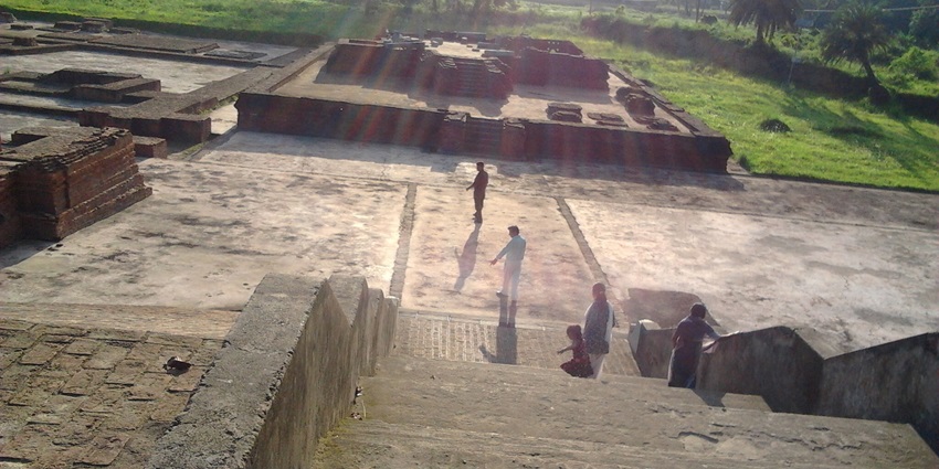 Participants at a workshop engaging with the ruins of Vikramshila University, showcasing stone structures.