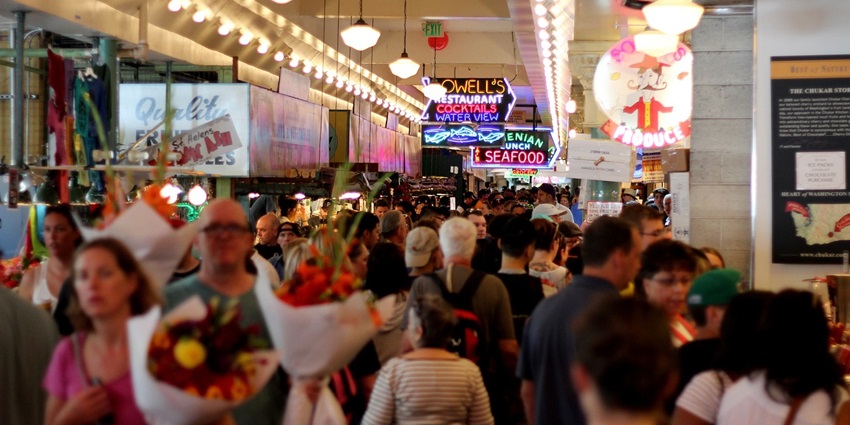 Shopping in Pattaya mall with signs and crowds of people moving in different directions.