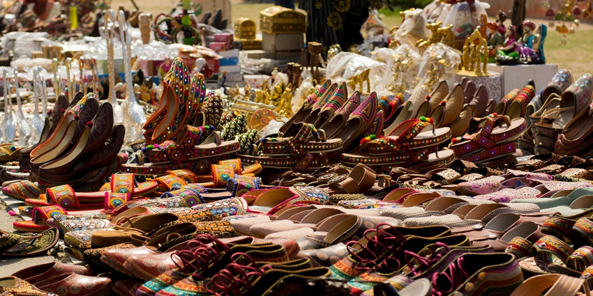 A lively marketplace with illuminated shopfronts, colorful textiles, and handcrafted souvenirs.