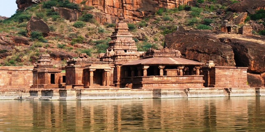 A glimpse of a temple made of red sandstone and majestic cliffs at Badami, Karnataka.