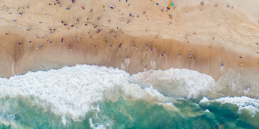 An aerial view of the famous Calangute Beach decked with people relaxing on the shores.