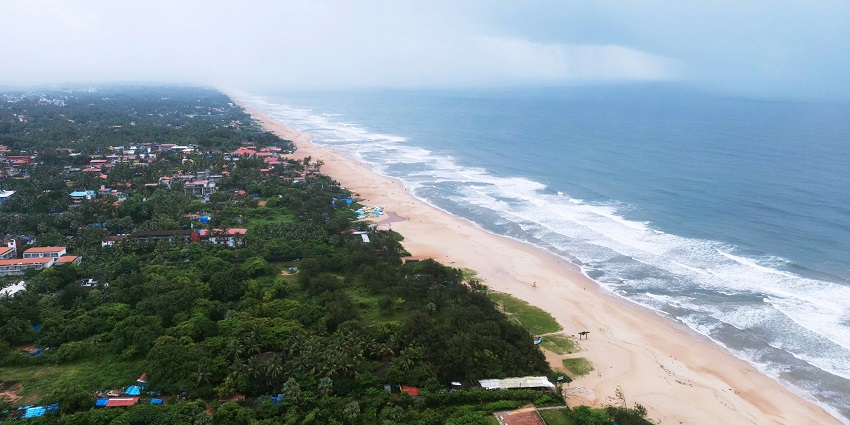 An aerial view of the lush greenery, golden sands, and serene waters of Baga Beach.
