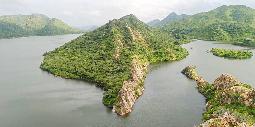 Bahubali Hills in Udaipur, Rajasthan, showcasing lush greenery, the serene Badi Lake, and the distant Aravalli hills