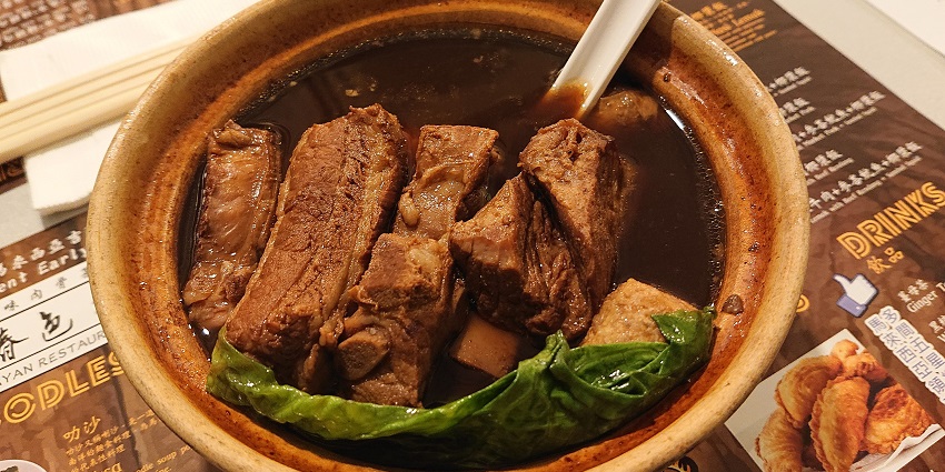 A hearty bowl of Bak Kut Teh, a pork rib soup in a rich herbal broth, served in Singapore.