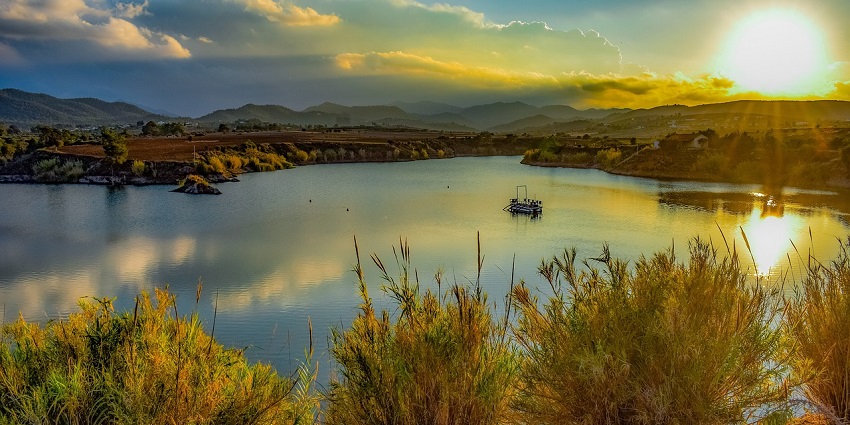 A view of the Bamera dam, surrounded by lush greenery and rolling hills, reflects the serene landscape and natural beauty of the area.