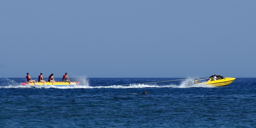 A glimpse of people enjoying a banana boat ride attached to a giant boat in Goan waters.