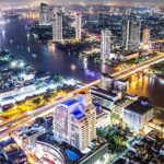 An aerial view of the Bangkok skyline at night which is a famous spot for rooftop parties