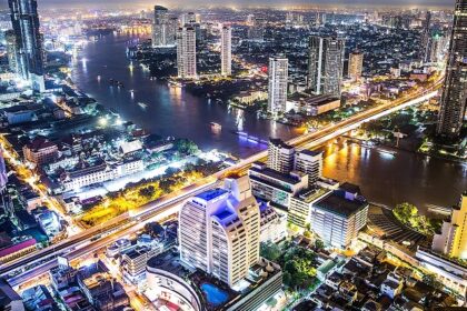 An aerial view of the Bangkok skyline at night which is a famous spot for rooftop parties