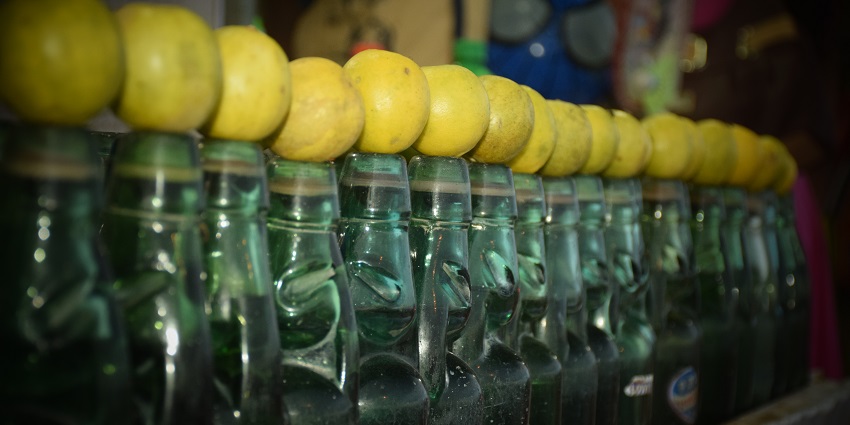 A refreshing bottle of Goli soda with a slice of lemon, showcasing vibrant colours