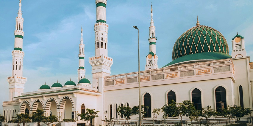 A large white building with a green dome, showcasing architectural grandeur.