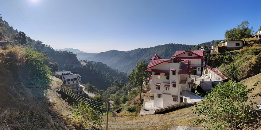 A picture of a lush green hill station with Himalayan views in Himachal Pradesh