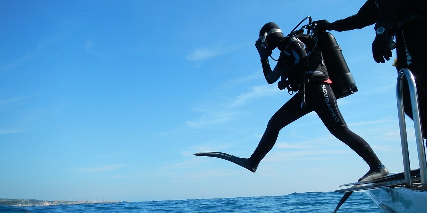 Image of a man in scuba diving suit read for diving during day time clear blue sky and water