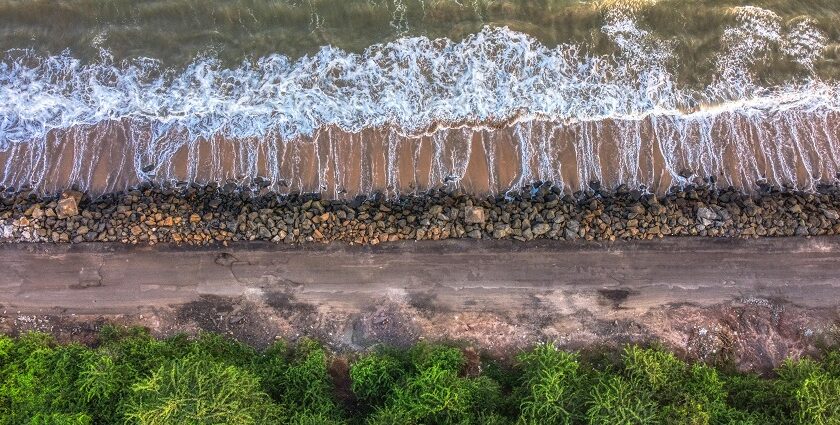 An aerial view of the turquoise blue waters touching the shorelines at the beach.