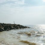 An image of a beach featuring golden sands, clear blue waters, and a peaceful shoreline.