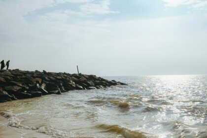 An image of a beach featuring golden sands, clear blue waters, and a peaceful shoreline.