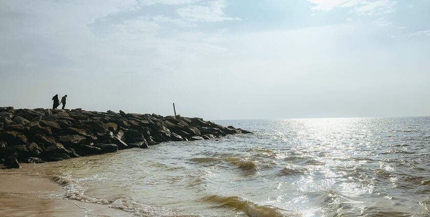 An image of a beach featuring golden sands, clear blue waters, and a peaceful shoreline.