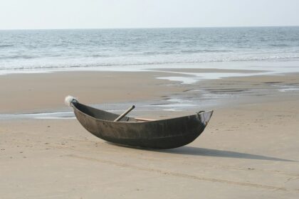 A breathtaking view of one of the Beaches in Kumta with a wooden boat on the shore.