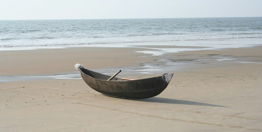 A breathtaking view of one of the Beaches in Kumta with a wooden boat on the shore.