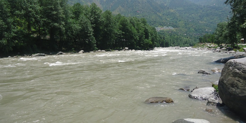 A beautiful view of the Beas River flowing through the lush mountains of Kullu and Manali