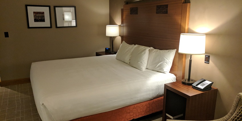 A picture of a hotel room with a cosy ambience and lamps on both sides