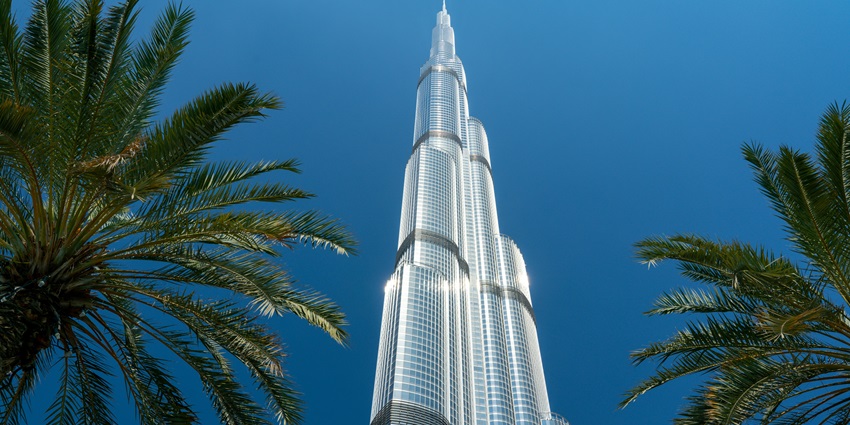 A breathtaking view of the world’s tallest building in Dubai around trees during the day.