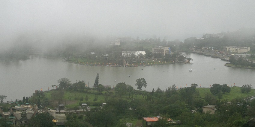 Rainy Gujarati monsoon scene near Jalaram Temple, with lush greenery and wet surroundings.