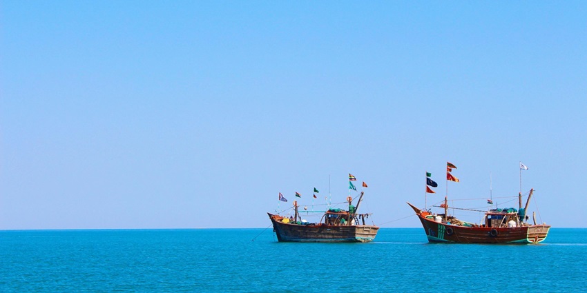 A breathtaking view of a body of azure waters with two boats on it during the daytime.
