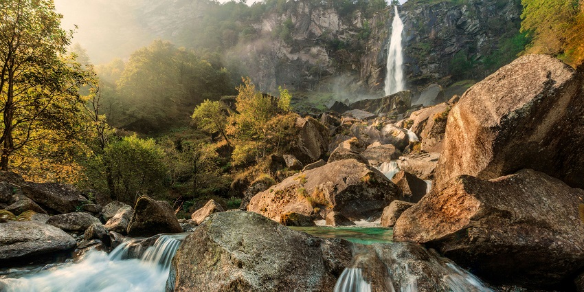 Image of a serene waterfall cascades through lush greenery under bright daylight
