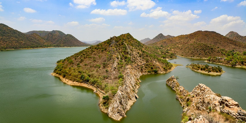A breathtaking view of the surroundings of the Sajjangarh Fort with waters and greenery.