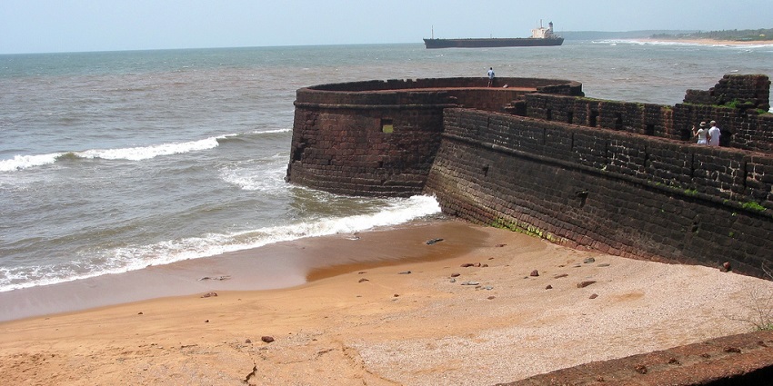 Clear blue waves crashing the sandy shores at the fort walls
