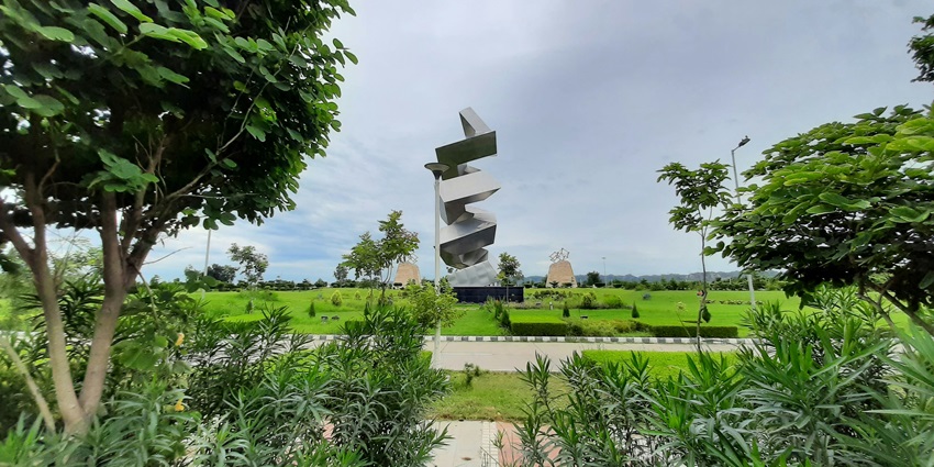 A stunning view of Punjab with lush green meadows during the daytime with a windmill.