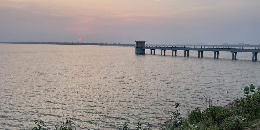 The Beni Sagar Dam in Khajuraho, Madhya Pradesh, surrounded by lush greenery and rocky hills.