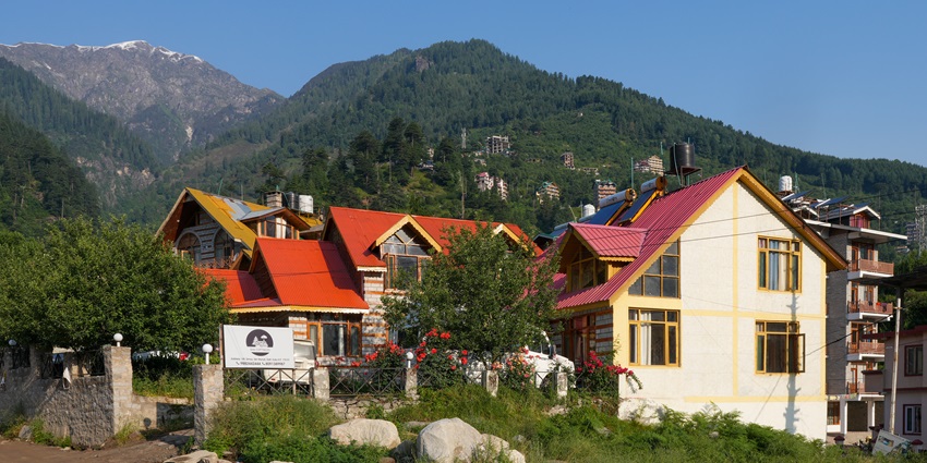 Cosy cottages surrounded by lush greenery and trees in Simsa, Manali, Himachal Pradesh near locations with rock climbing in Manali.