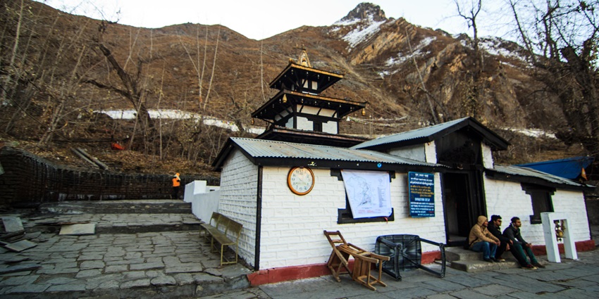 Muktinath Temple in Mustang, Nepal, surrounded by mountains and clear deep blue sky.