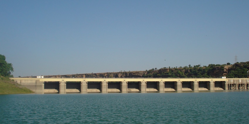 A distant picture of a dam over a lake in Madhya Pradesh surrounded by greenery