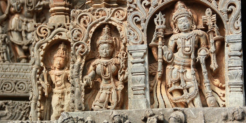 Carvings of small sculptures on the walls of a temple representing the Lords and their attires.